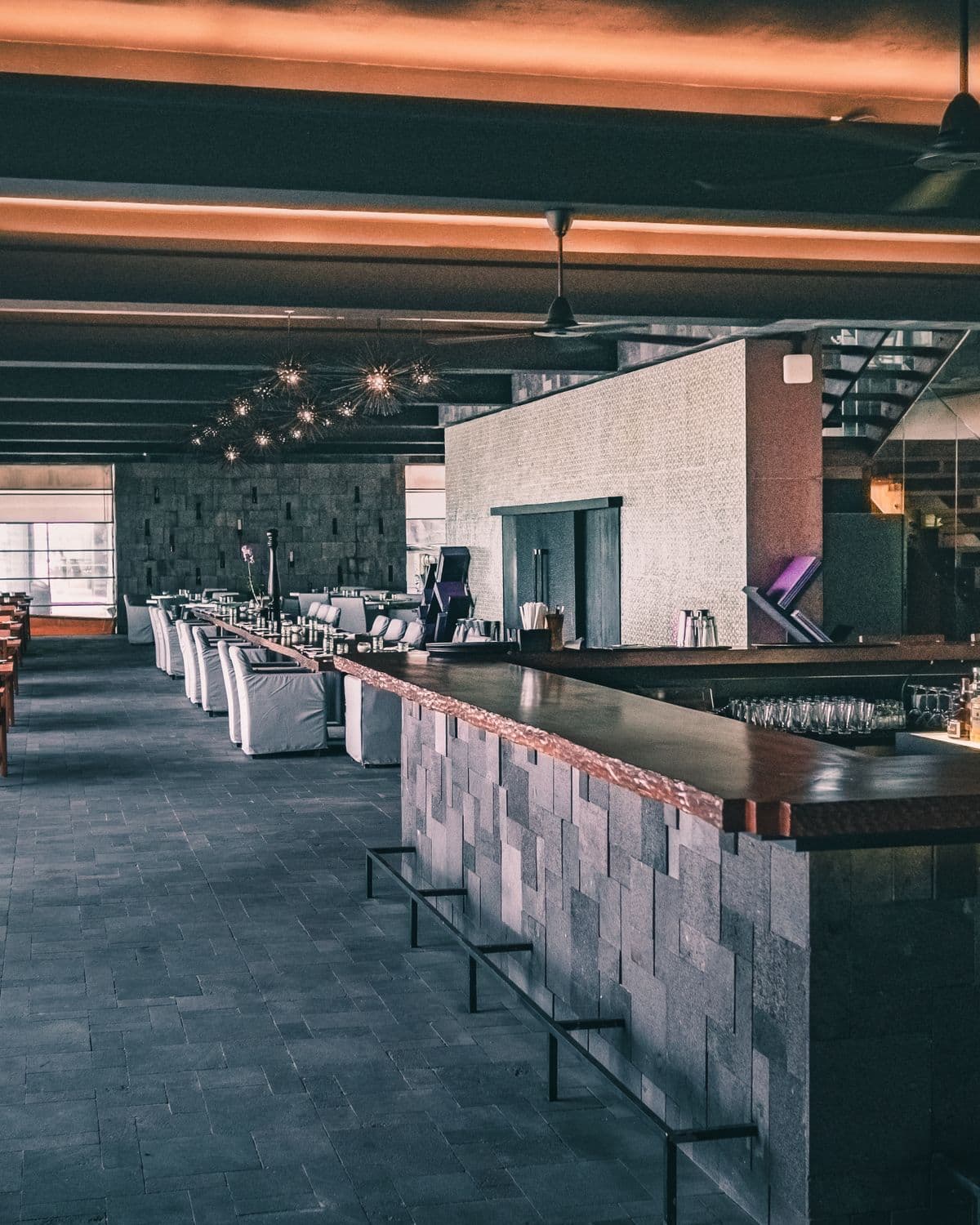 The long bar at night, glassware lined up under low light